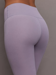 Model wears lavender grey, high-rise ribbed leggings with a fitted, full-length silhouette.