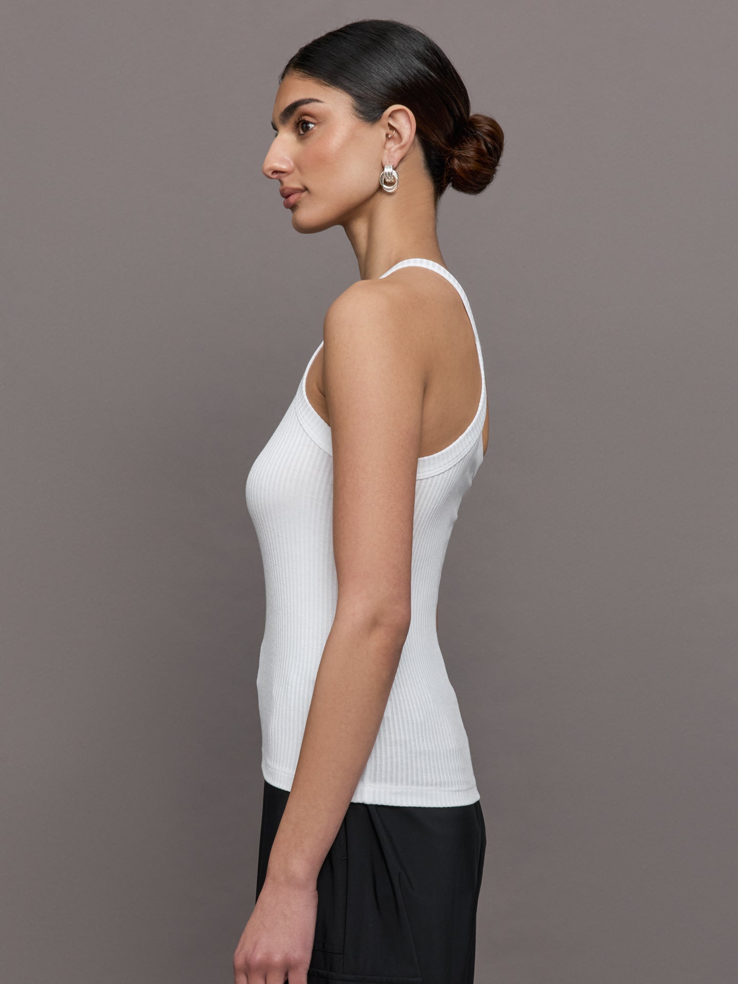 Model wears a white ribbed one shoulder tank.