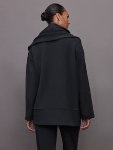 Model wears black open-front cardigan with a loose, draped fit, wide bell sleeves, and side pockets.