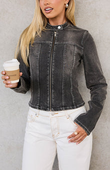 Close-up front view of a washed black denim biker jacket with a stand collar, vertical seam detailing, and white contrast stitching