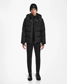 A person stands facing forward wearing the Rudsak JACK - M124507 Black quilted winter jacket on a plain white background.