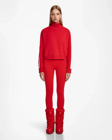 A woman wears the Rudsak KELLIE - 8524615 Flame Red womens mock neck top in scuba fabric.