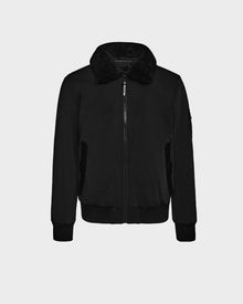 The Rudsak REECE - 6124592 Black mens bomber jacket features a zip-up front, black faux fur shearling collar, ribbed cuffs and hem, water-resistant fabric, and two zippered side pockets, shown on a plain light background.