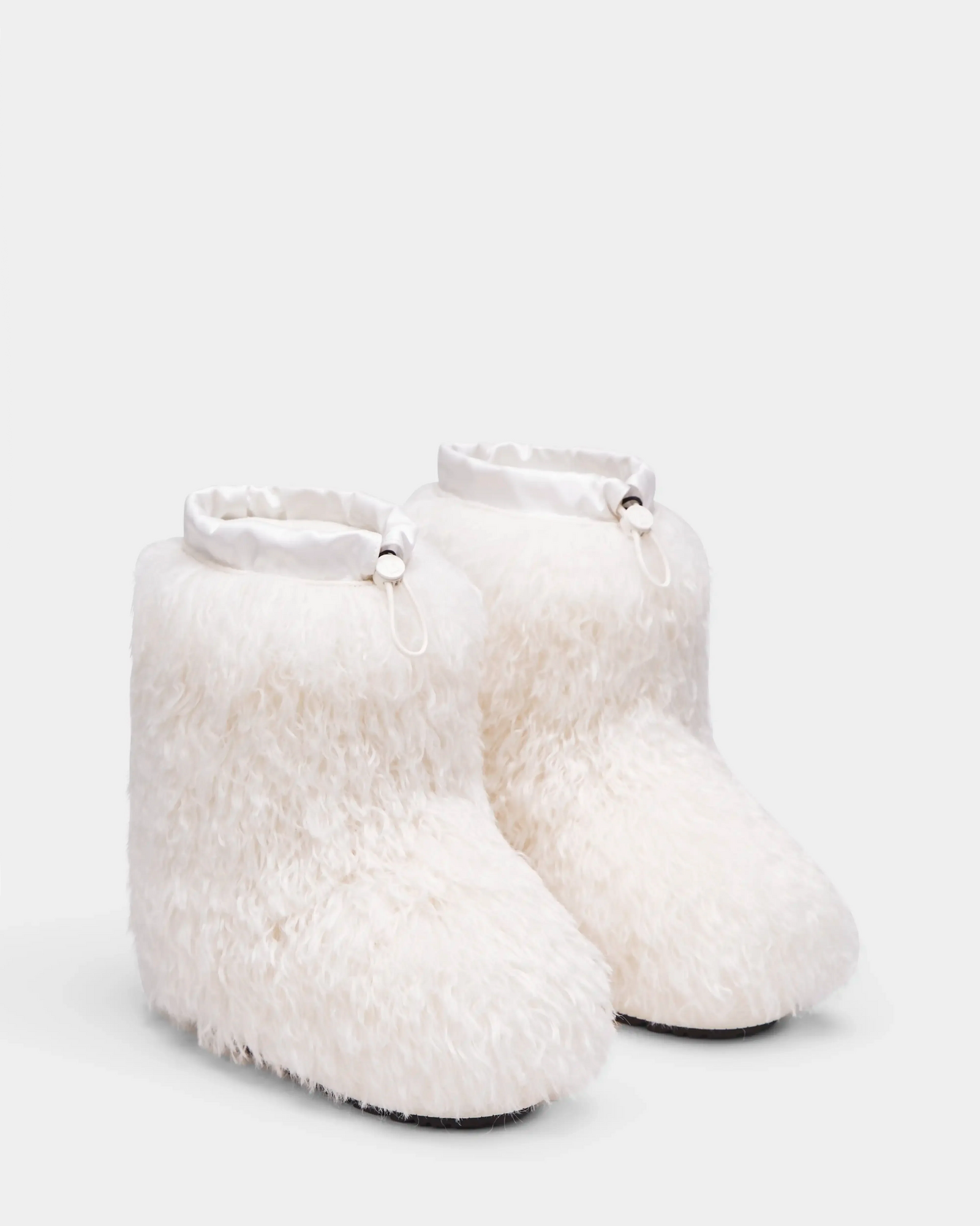 A pair of ROSSY - 8224518 Iceland white Mongolian fur boots by Rudsak with satin-like drawstring collars, displayed on a plain light background—perfect women’s winter boots for cozy style and warmth.
