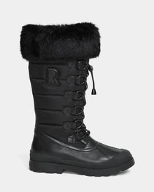 The WINDY - L224507 Black by Rudsak is a tall women's winter boot with cold-weather comfort, faux fur trim, lace-up front, quilted shaft, signature R patch on the side, and a sturdy rubber sole.