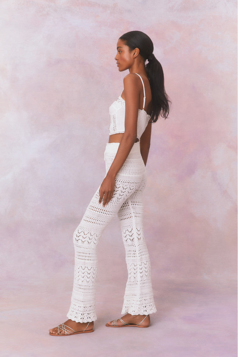 White cotton pointelle crochet floral flare pants with a self tie detail at center front on the double ribbed waistband.