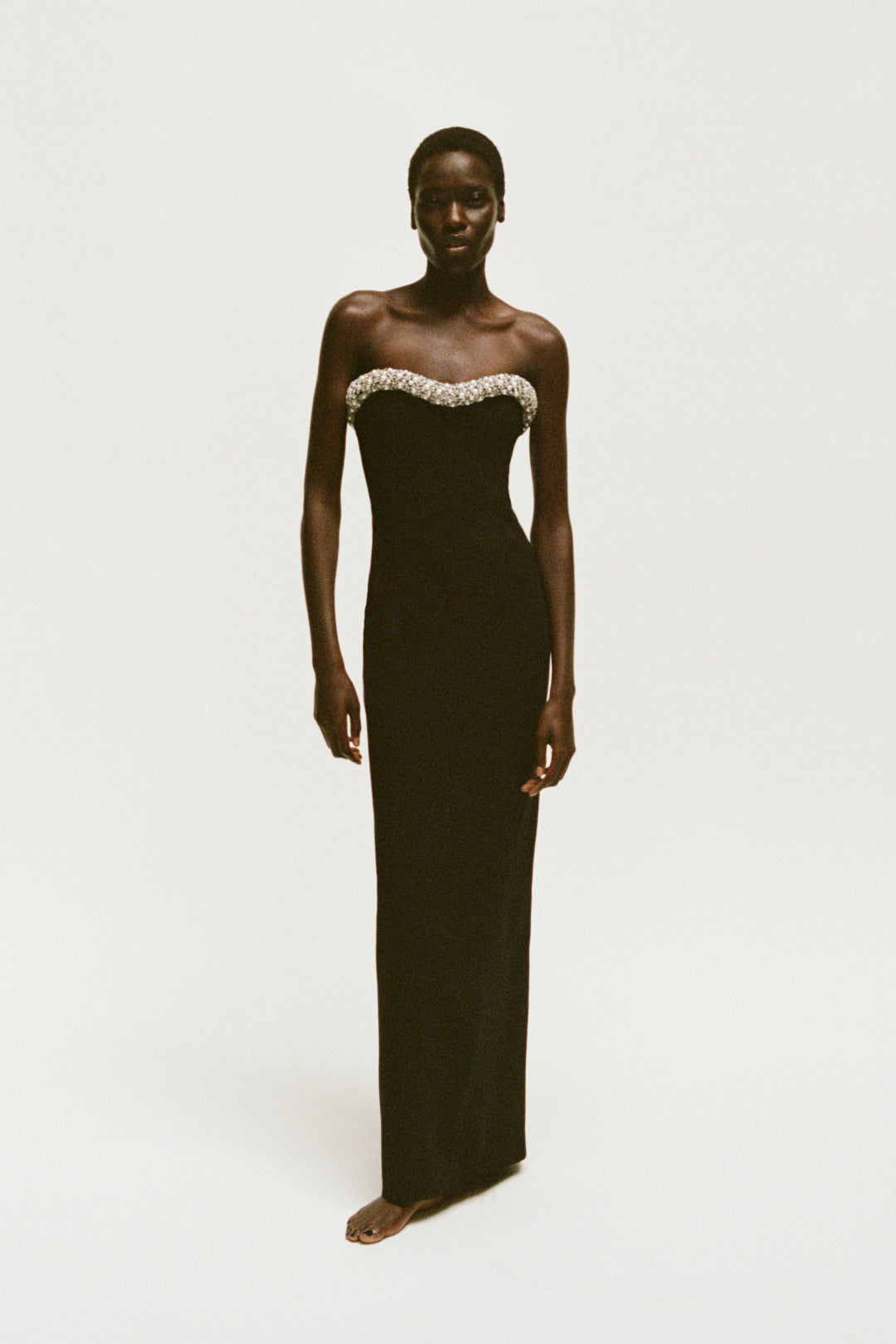 Black strapless floor-length gown with crystal embellishments along the neckline.