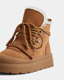 A close-up of Rudsak's ALEXEY - L225025 Tan women's suede winter boot, featuring thick brown laces, metal eyelets, a chunky rubber sole, and a soft wool lining visible at the top for extra warmth and comfort.