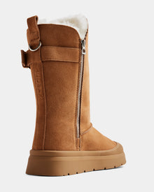 The KLAIR - L225027 Tan by Rudsak is a women’s mid winter boot in tan suede with a thick rubber sole, visible side zipper, pull tab, and soft white wool lining. Features the brand name on the side strap. Shown on a plain white background.