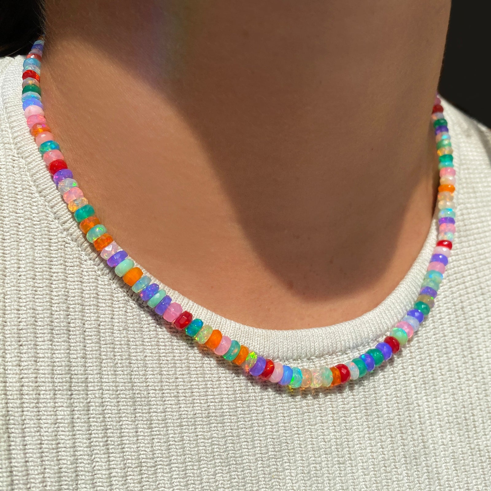 Faceted Tie Dye Opal Necklace over a whit knit top.