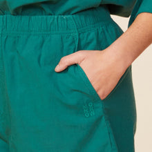 Detail view of model wearing the poplin shorts in galapagos green.