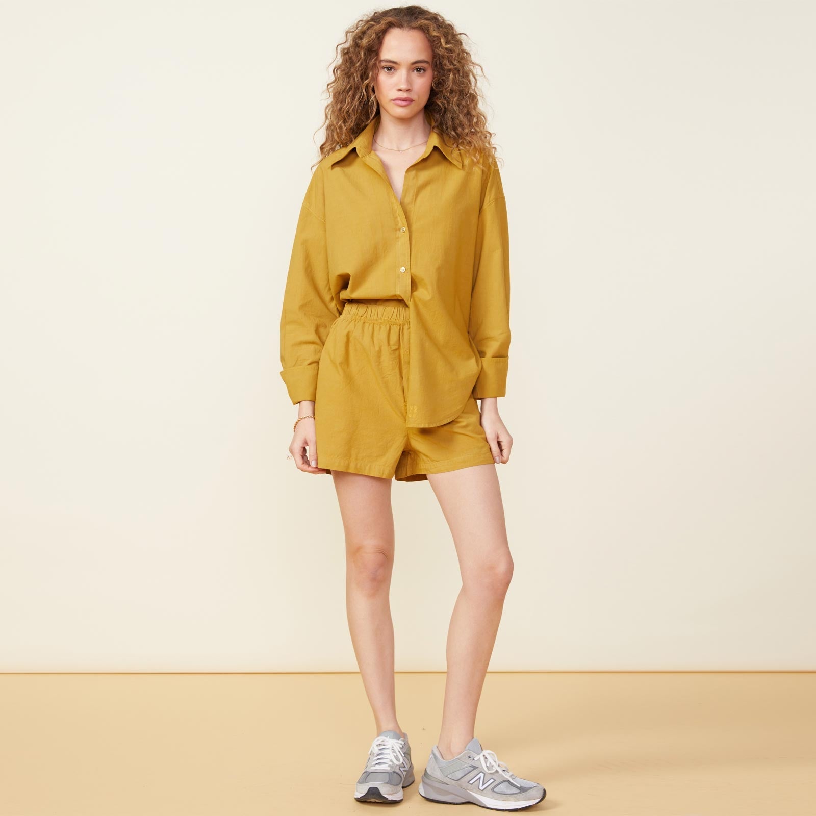 Front view of model wearing the poplin shorts in golden olive.