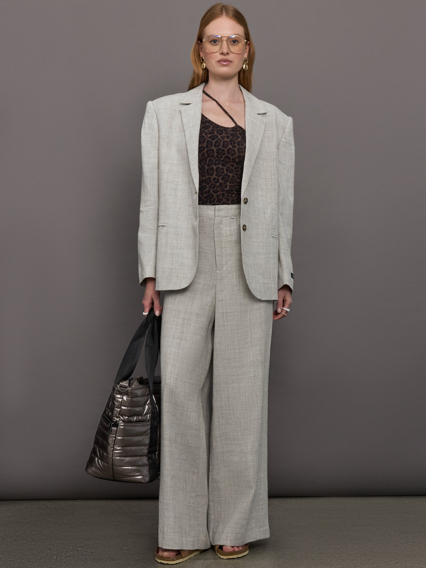 Model wears a gray/taupe textured oversized blazer with single button closure.