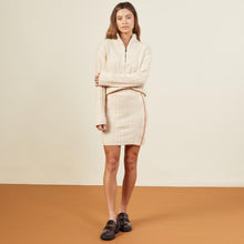 Front view of model wearing the sweater mini skirt in off white.