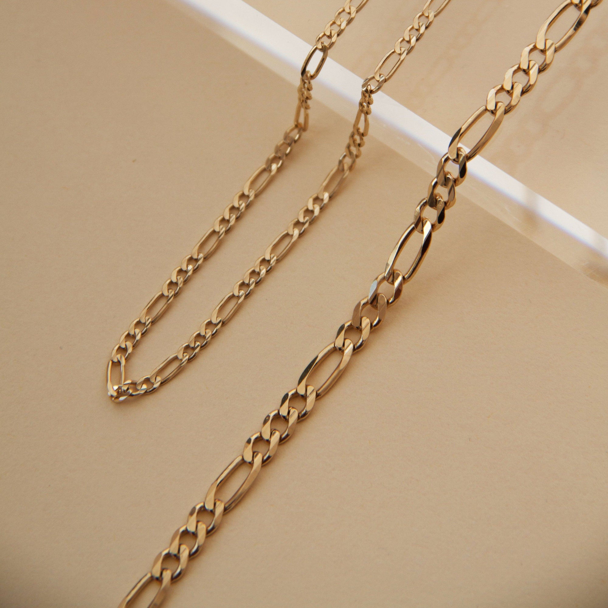 Flatlay Model. Close up of gold chain bracelets on neutral background