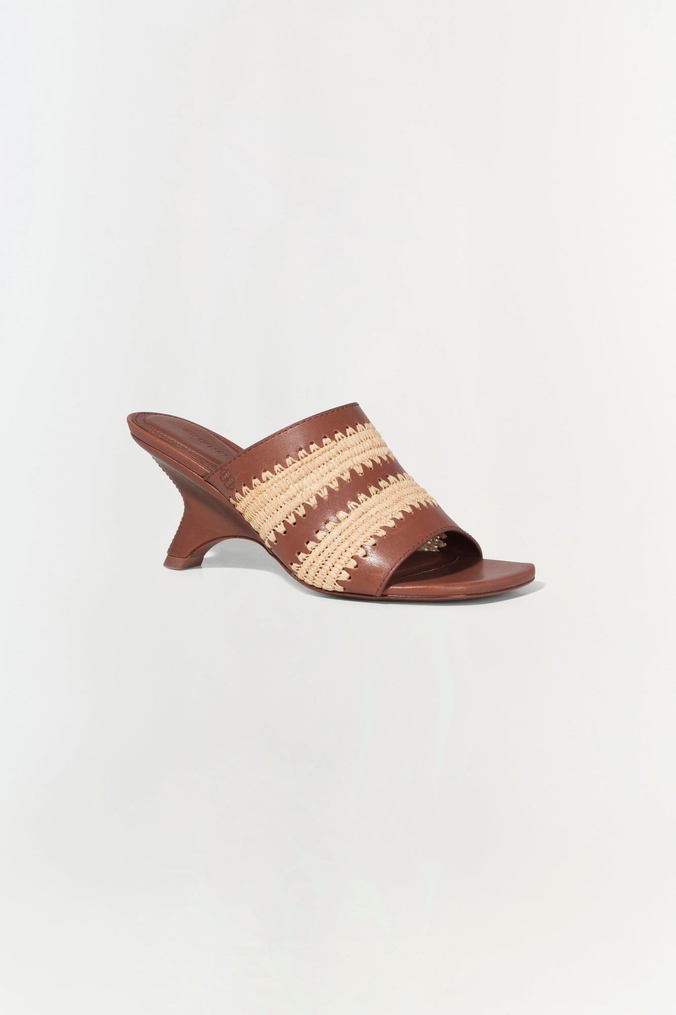 Brown leather mule sandal with natural raffia striped upper and curved heel.