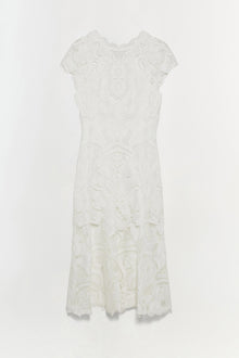 White lace dress with short sleeves, intricate floral patterning throughout, and asymmetrical handkerchief hem.
