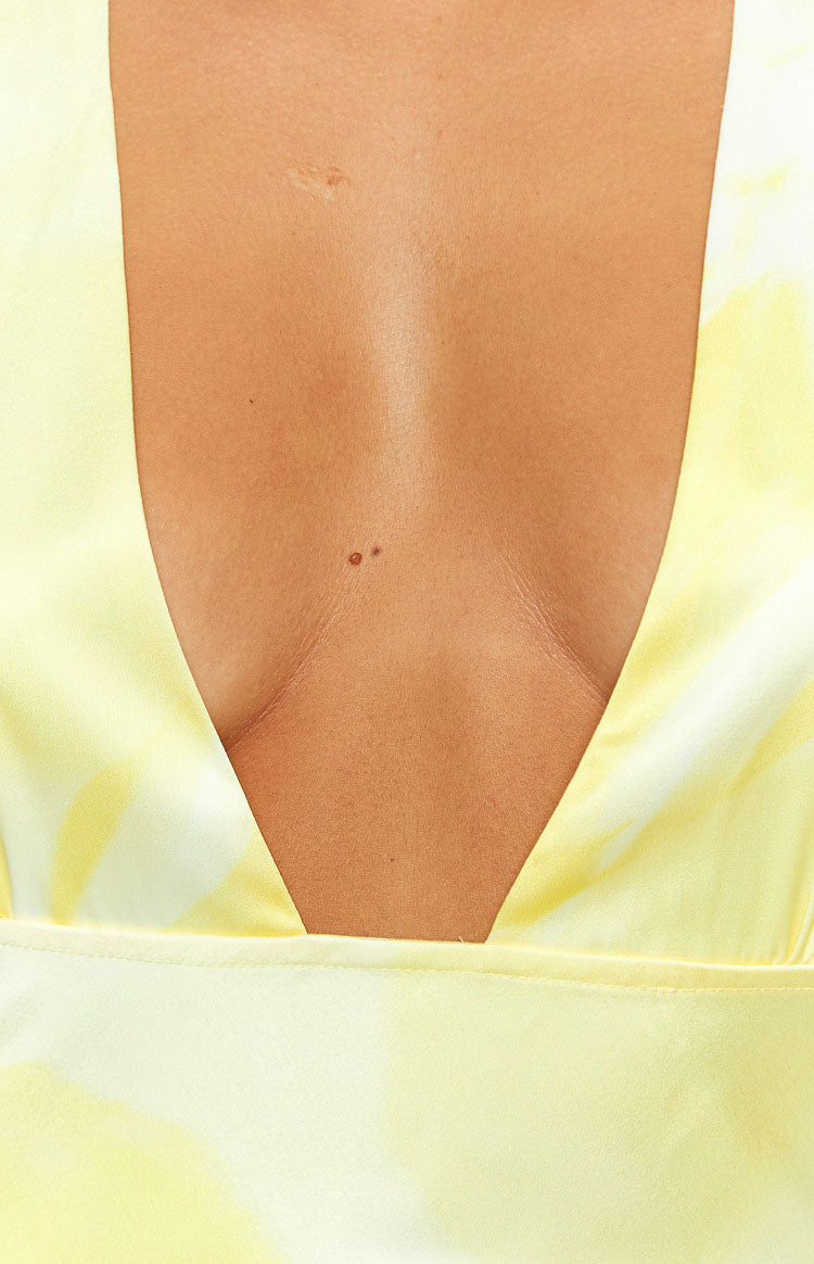 Rear view of a yellow and white tie-dye maxi dress with a halter neck tie and low scoop back
