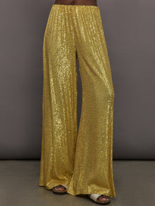 Model wears the Boyfriend Elephant Sweatpants in Asparagus, featuring a relaxed, tapered fit with oversized legs and sparkles.