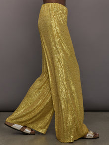 Model wears the Boyfriend Elephant Sweatpants in Asparagus, featuring a relaxed, tapered fit with oversized legs and sparkles.