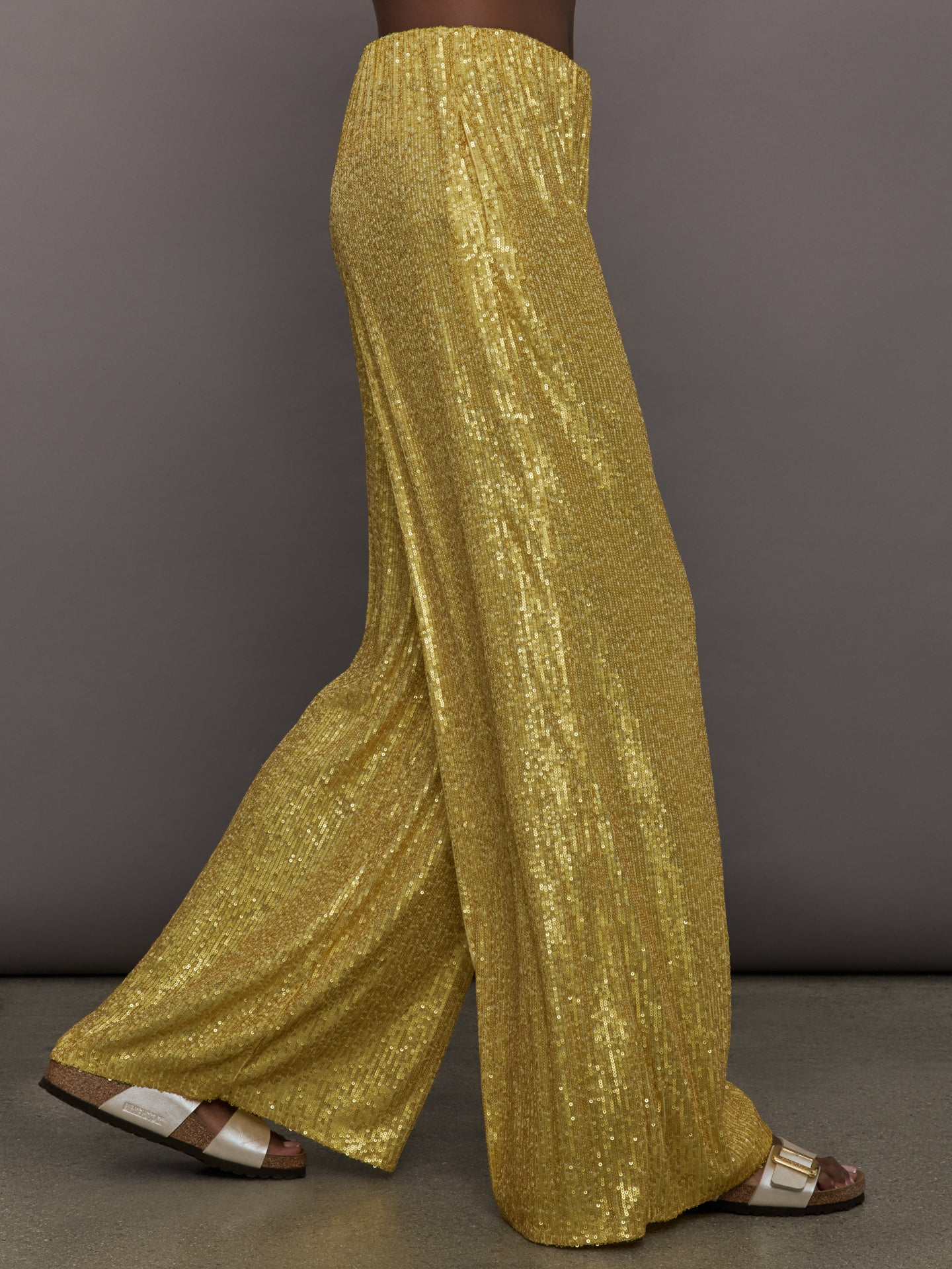 Model wears the Boyfriend Elephant Sweatpants in Asparagus, featuring a relaxed, tapered fit with oversized legs and sparkles.