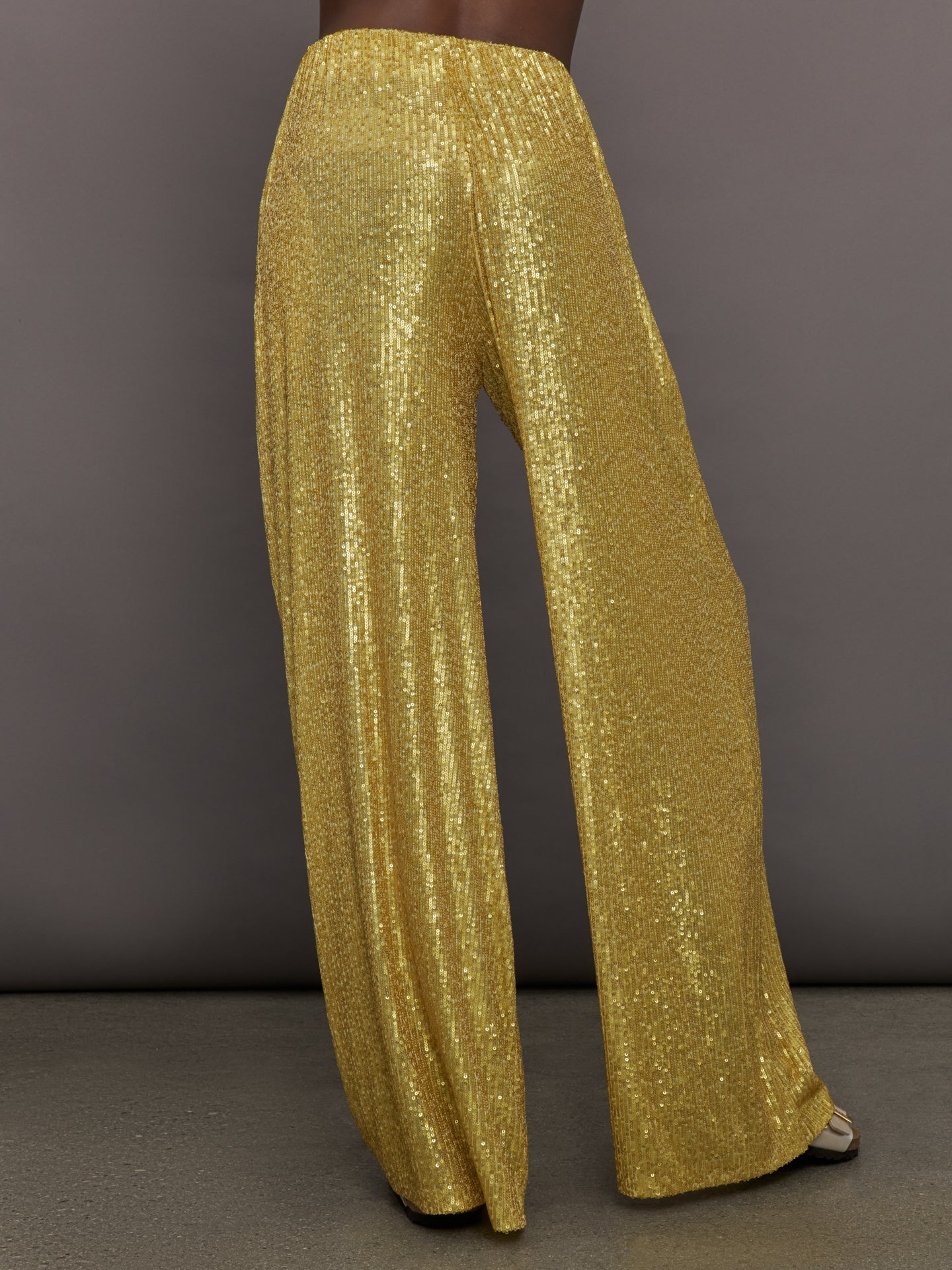 Model wears the Boyfriend Elephant Sweatpants in Asparagus, featuring a relaxed, tapered fit with oversized legs and sparkles.