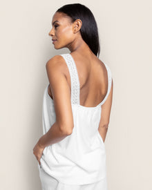 A person with long hair is wearing the Womens Pima Camille Short Set in White by Petite Plume, evoking elegant and luxurious pajamas. They glance over their shoulder against a plain light-colored background.