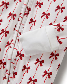 The Baby's Pima Peekaboo Romper in Blissful Bows is a white long-sleeve onesie with cuffs, adorned with festive red bows and a convenient back zipper.