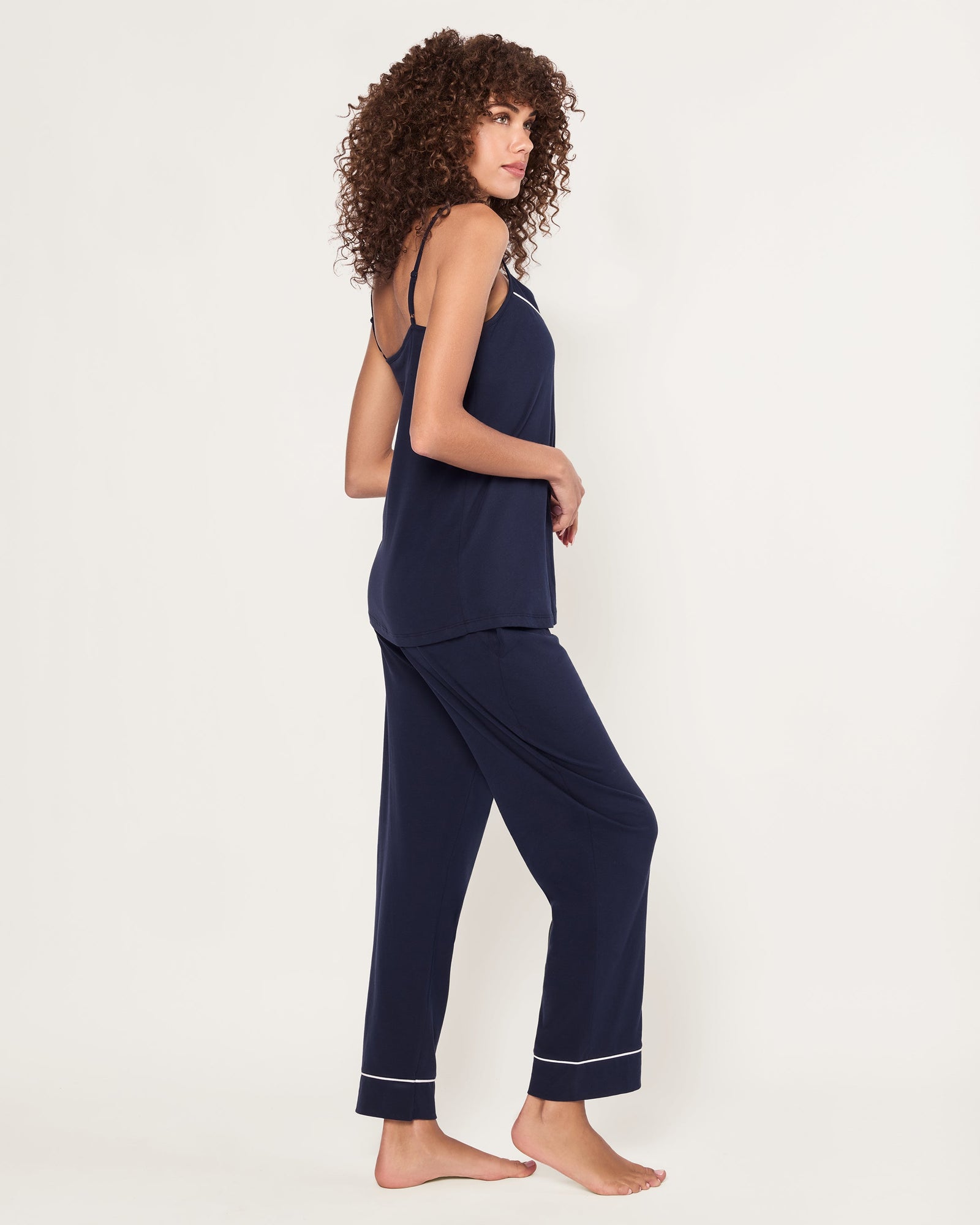 The Women's Pima Sylvie Pajama Set in Navy includes a sleeveless V-neck camisole with thin straps and matching long pants, both featuring white trim. The set is displayed flat on a white background.