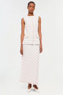 Woman wearing a sleeveless button-front vest in light pink and white gingham check with matching maxi skirt.