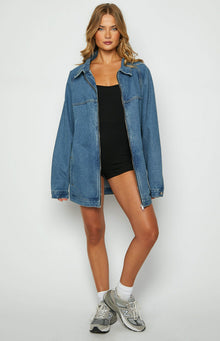 Blue oversized denim jacket with a full-length silver zipper and classic collar, showing the relaxed fit