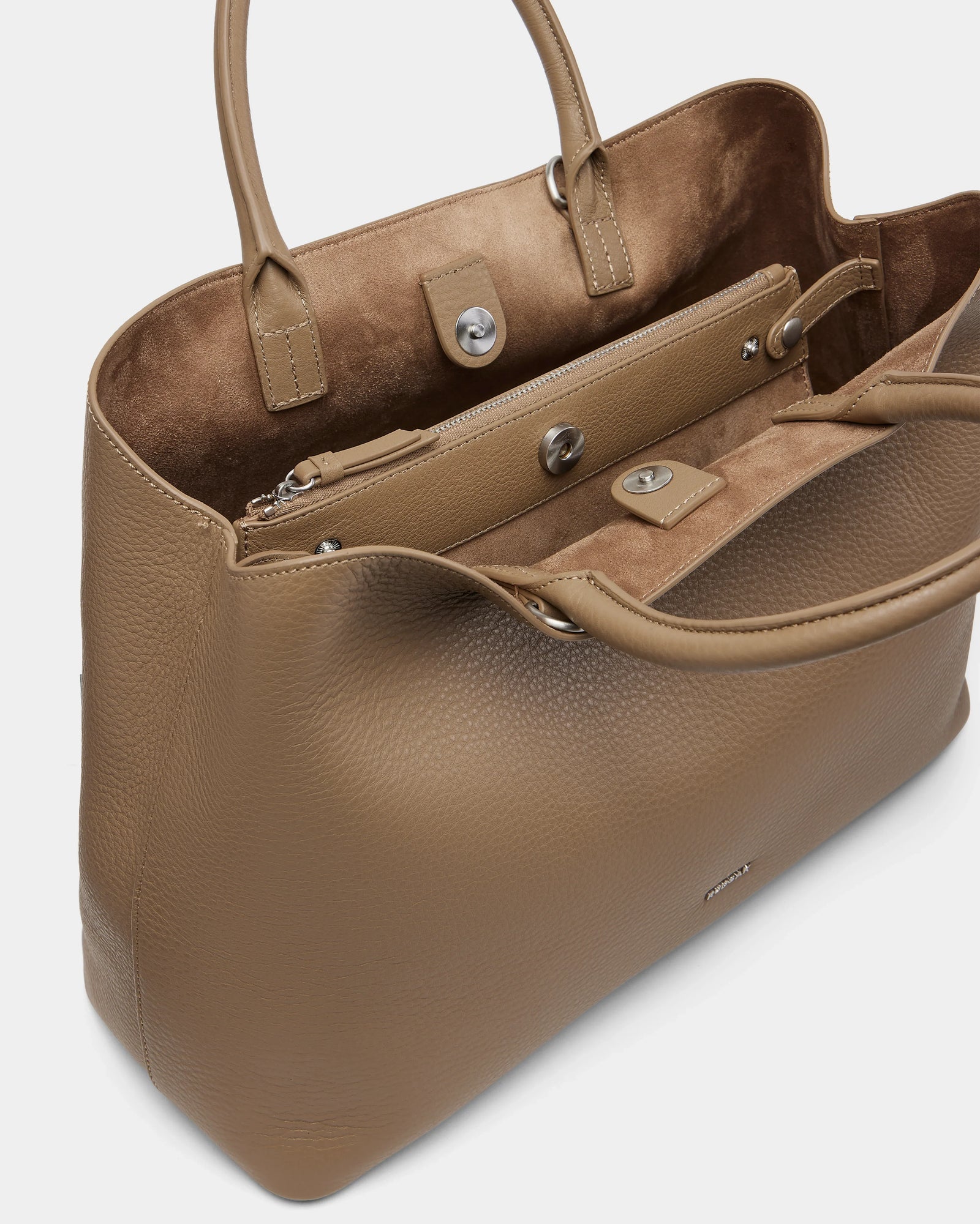 The Rudsak CATIRA L - 8325007 Almond tote features taupe pebble leather, a spacious suede-lined interior, zippered pouch, and snap button closures—making it a chic statement accessory for any wardrobe.