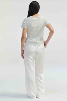 Person wearing a white outfit on a light gray background
