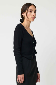 Woman wearing a black cardigan and skirt on a white background