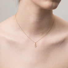 Model Close-up of a woman wearing a delicate gold chain necklace featuring a small diamond-encrusted 'S' pendant