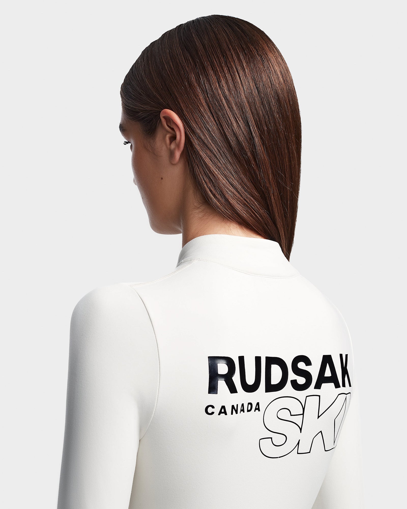 A woman wearing the Rudsak DAVINA - 8523534 Iceland white fleece-lined bodysuit.
