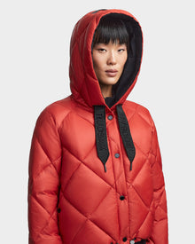 A person wears the Rudsak BALA - 8123614 Orange women's quilted winter coat with black 