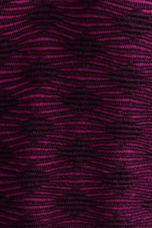 Detail shot of the Amelie Polo showcasing the monochromatic textured pattern in fuchsia and aubergine. Ethically made from baby alpaca and cotton.