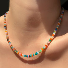 Single desert-disco multi colored opal necklace on the neck.