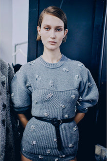 Gray knit sweater with scattered silver beaded embellishments, crew neckline, and ribbed texture throughout.