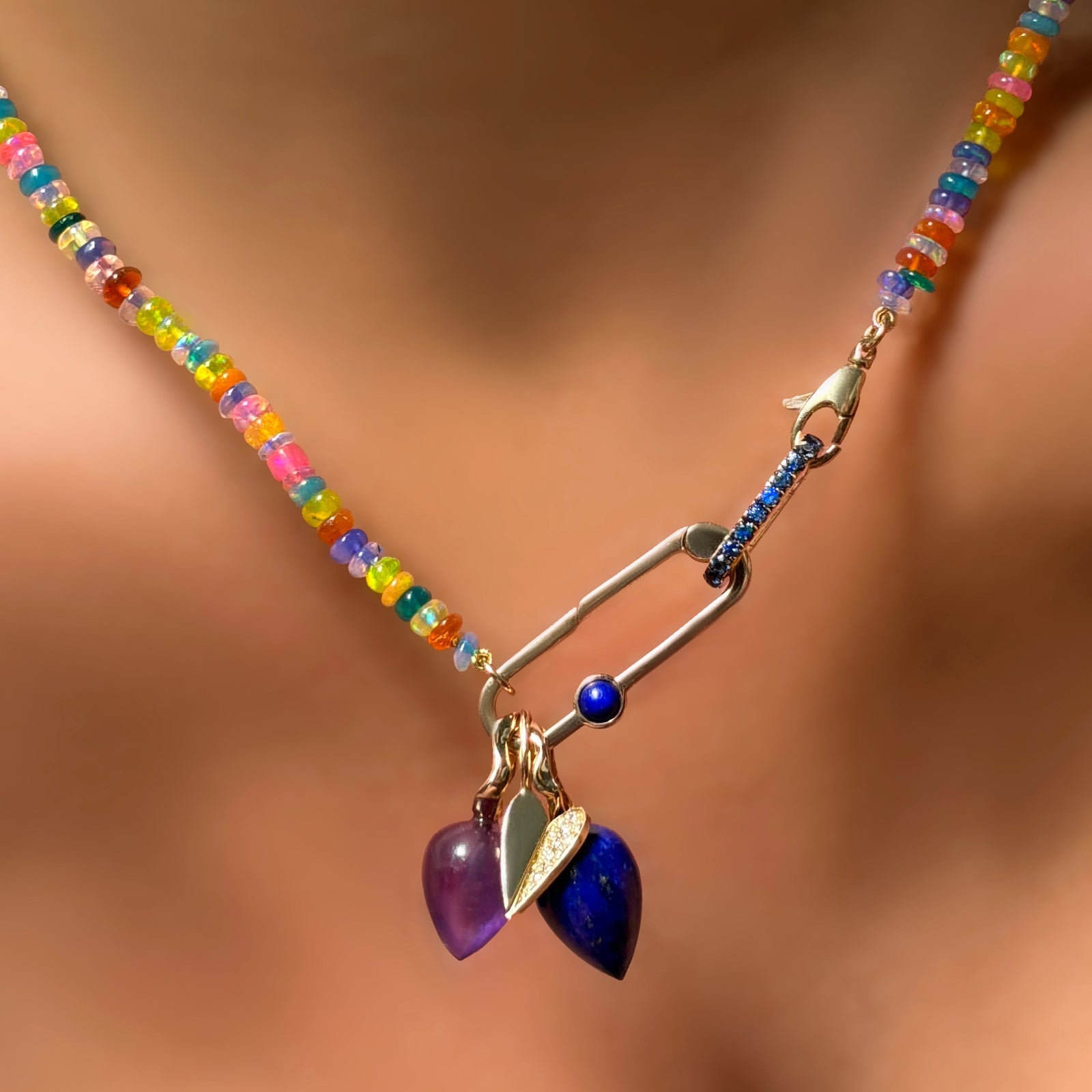 Garden party opal necklace with sapphire charm lock, and paperclip charm lock with lapis, with an amethyst and lapis drop charm along with a half pavé folded heart charm on the neck.