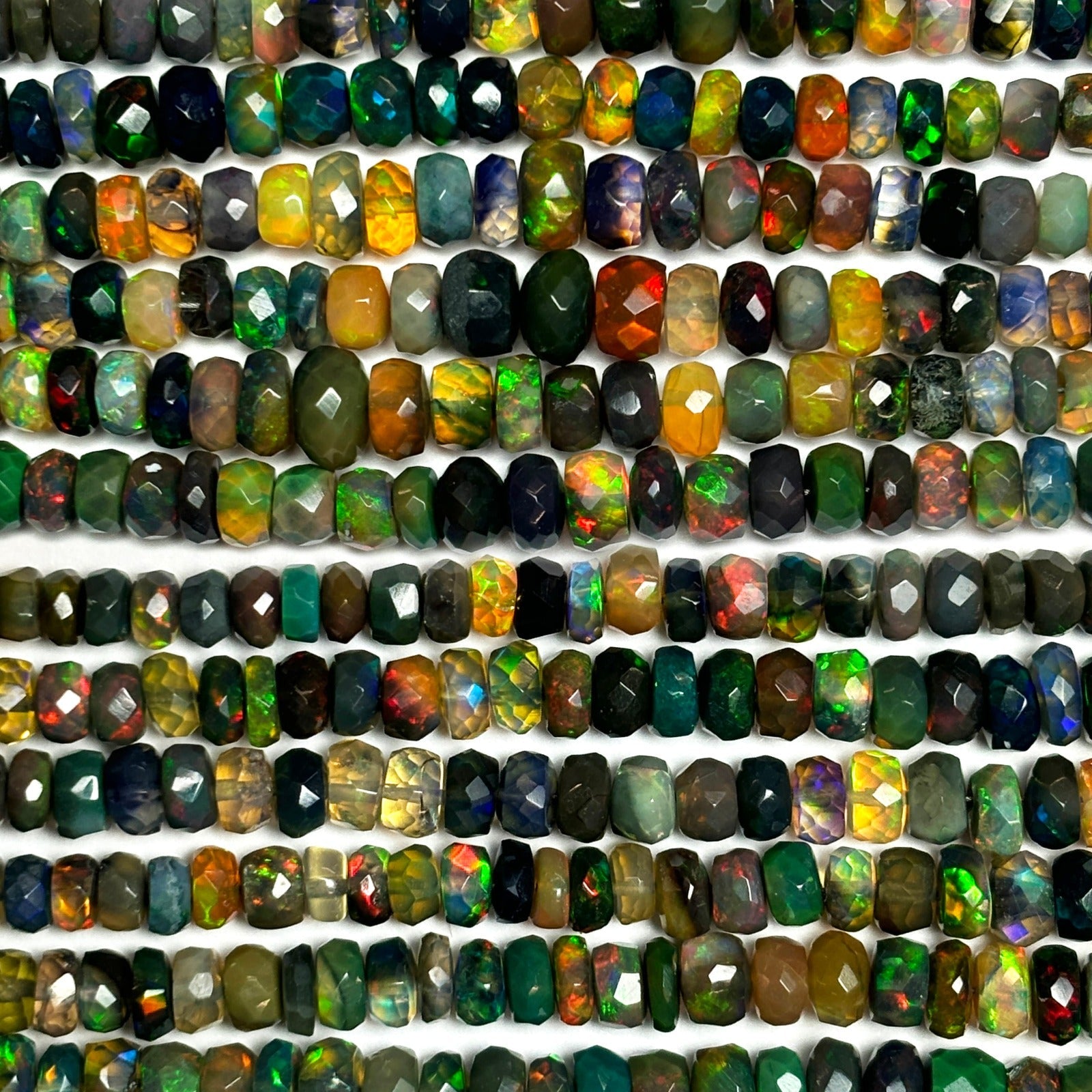 Shimmering beaded necklace made of faceted opals in shades of green, yellow, and blue on a gold linking ovals clasp, Opal swatch on white background