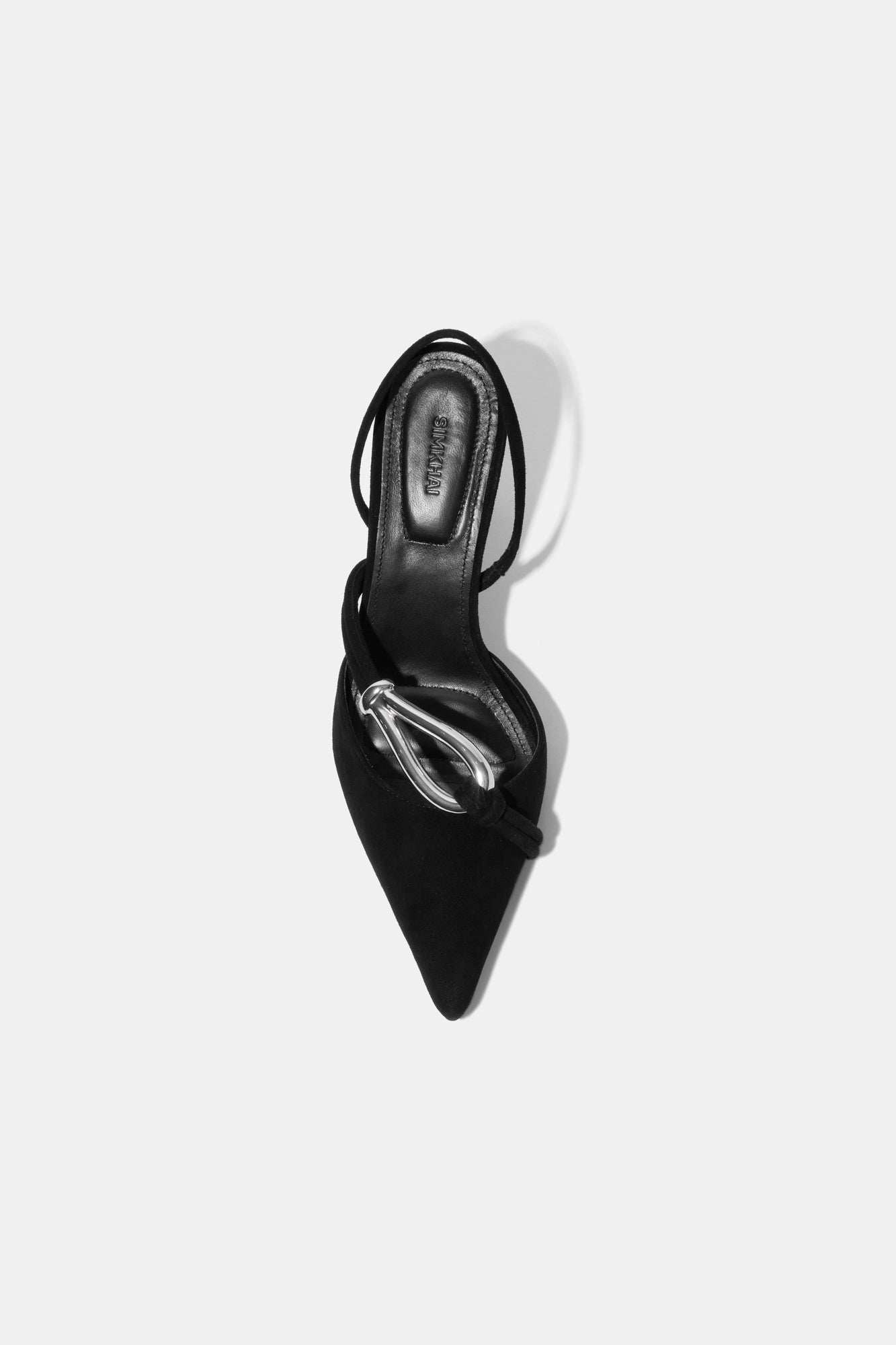 Black suede slingback pump with pointed toe and silver love knot detail on the vamp, shown from above.