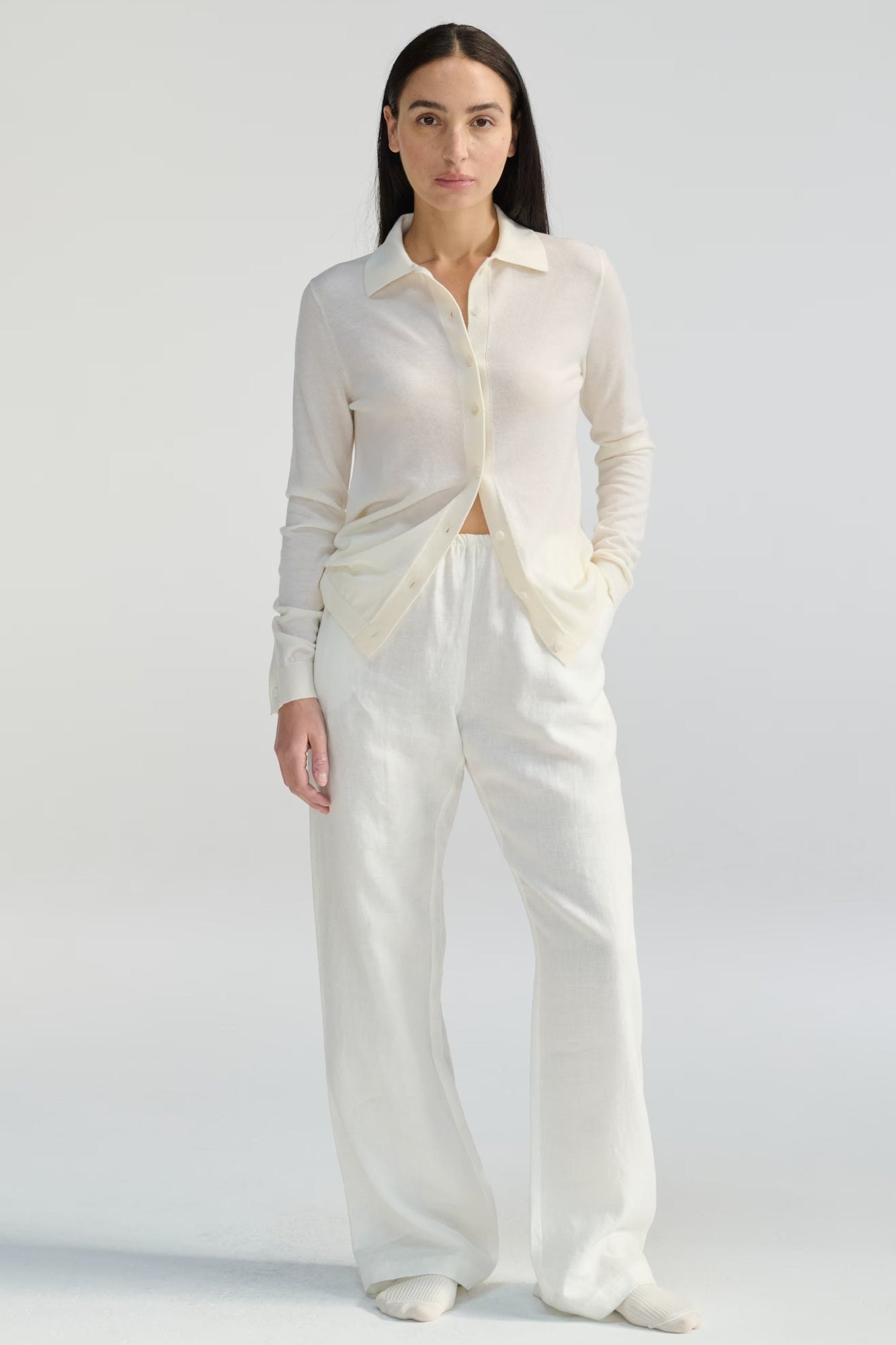 Woman wearing a white outfit on a plain background